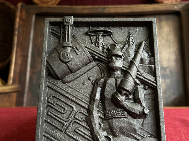 Close-up of the European Science Fiction Award plaque featuring a futuristic sculpted figure and machinery, displayed at the National Leprechaun Museum.