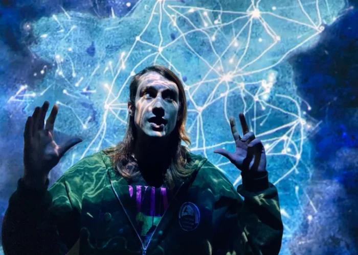 Storyteller illuminated by glowing blue constellations during an immersive Irish mythology presentation at the National Leprechaun Museum.