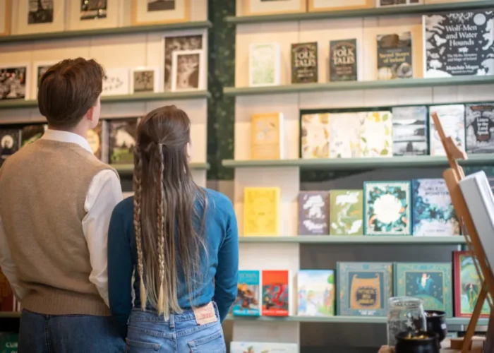 Young man and woman browsing shelves of Irish folklore books inside the National Leprechaun Museum’s storytelling-themed gift shop.
